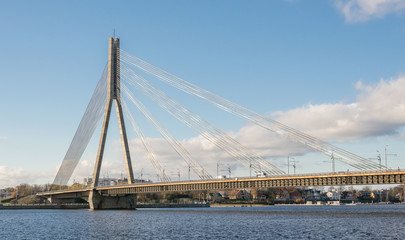 Сable bridge over the river Daugava in Latvia on the blue sky and white clouds background. Cable bridge over the river.