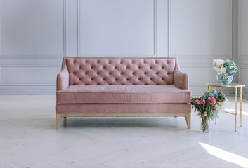 Pink couch against the grey wall