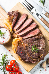 Grilled beef steak ribeye on wooden cutting board. 