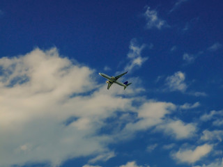 Fototapeta na wymiar Commercial airplane flying under the clouds