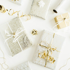 Golden gift boxes, decorations on white background. Flat lay, top view Christmas, New Year holiday gifts packaging concept.
