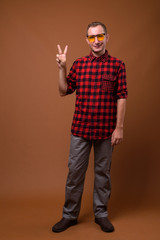 Studio shot of man against brown background