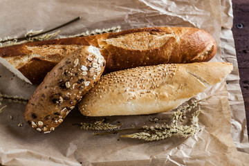 mix of different varieties of bread lying on a wooden table