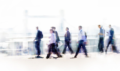 Group of business people walking over London bridge to the City of London. Early morning rush, modern life concept. Tower bridge at the background