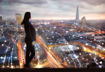 Young woman looking over the City of London at sun set. Future, new business opportunity and...