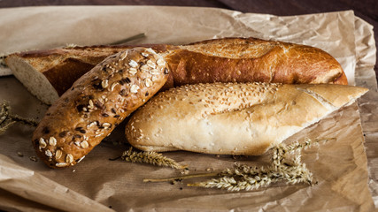 mix of different varieties of bread lying on a wooden table