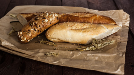 mix of different varieties of bread lying on a wooden table
