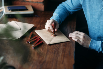 Close up view of using sealing wax on the envelope. Stamp