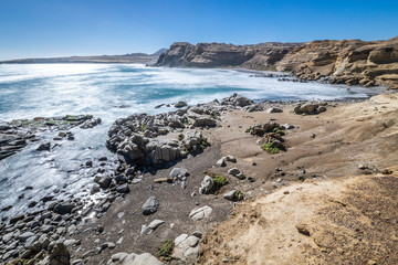 Chorrillos Beach white waters crashing with the coastline rocks during a long exposure shot at Chile with the Atacama Desert sands ending on the Pacific Ocean waters, maybe the best beaches in Chile