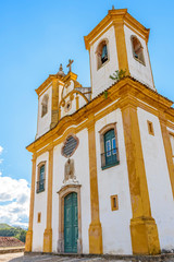 Facade of the church of Church of Our Lady of Mercy and Mercy in Ouro Preto, Minas Gerais with its windows, large wooden door, stone arch and baroque sculptures