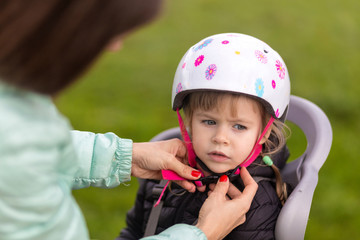 Putting your child on a bicycle helmet. Use a bicycle helmet