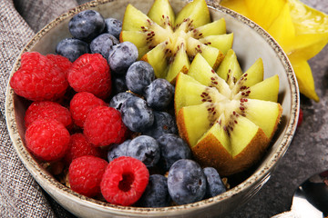 fruit bowl. Bowl of healthy fresh fruit salad on rustic background