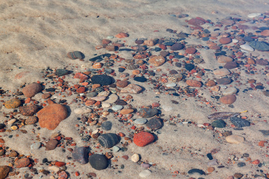 Multi-colored Pebbles On The Bottom Under Calm Crystal Clear Water