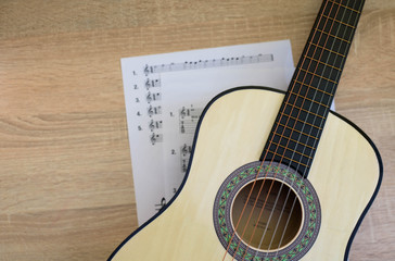 Fototapeta premium Classical guitar with tablature on the desk. Sun light. Top View