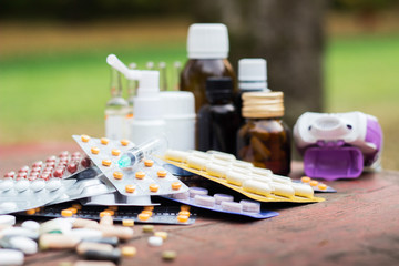Medicines on wooden table, nature bokeh background