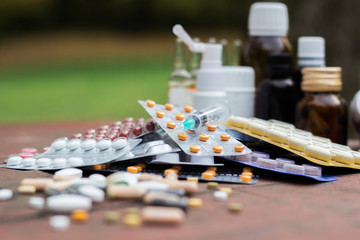 Medicines on wooden table, nature bokeh background