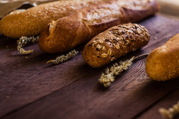 mix of sorts of baguettes on a wooden table. Bakery products.