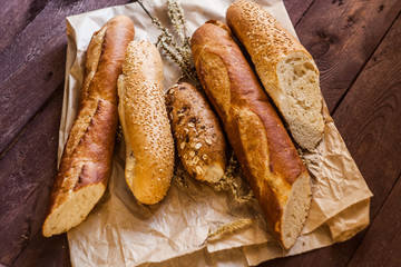 mix of sorts of baguettes on a wooden table. Bakery products.