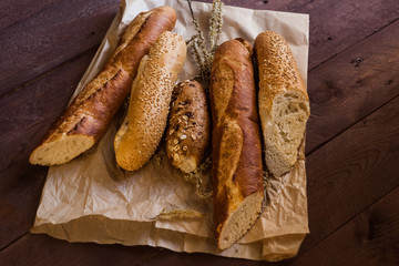 mix of sorts of baguettes on a wooden table. Bakery products.