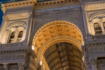 Milan, Italy. Arch of Galleria Vittorio Emanuele II in the evening with golden illumination, view from below