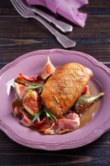Duck breast with pancetta, rosemary and figs, baked in honey sauce. vertical
