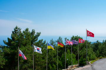 Flags in row Korea Ukraine Switzerland Turkey Germany United Kingdom Against Blue Sky   