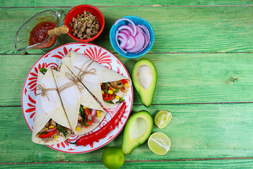 Taco - traditional dish of Mexican cuisine. Mexican tacos with beef, vegetables and sauce on a wooden background. Top view