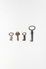 Four old keys on white background
