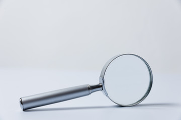 silver magnifying glass on white background