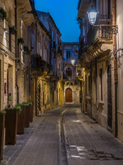 A picturesque road in Siracusa old town (Ortigia) at night. Sicily, southern Italy.