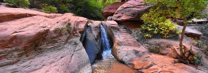 Kanarraville Falls, views from along the hiking trail of falls, stream, river, sandstone cliff formations Waterfall in Kanarra Creek Canyon by Zion National Park, Utah, USA.