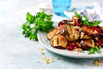 Grilled eggplants in tomato sauce with walnuts and pomegranate seeds.