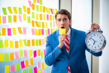 Young handsome employee with many conflicting priorities   