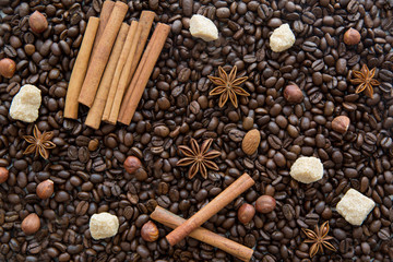 Coffee beans background with spices: anise and cinnamon sticks.