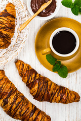 Chocolate Croissants for Breakfast on White Wooden Background. Selective focus.