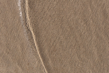 a thin layer of water mixed with sand at the time of the wave rollback