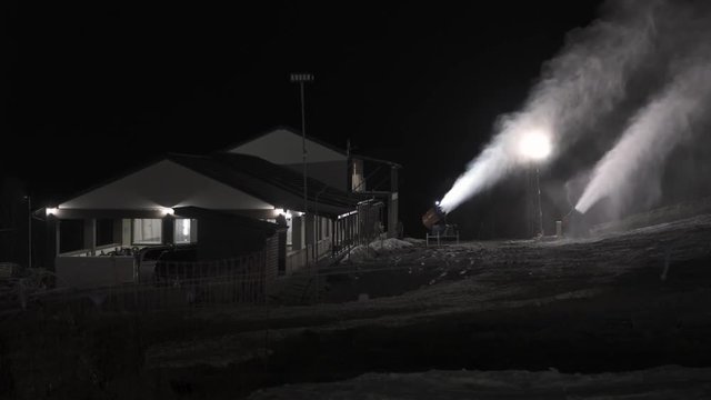 Snow making system in work. Several snow machines produce snow at night.
