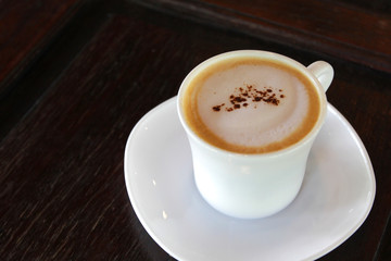 hot cappuccino coffee on wooden table