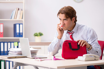 Man with first aid kit in the office