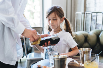 Teen girl pays in the restaurant with a credit card