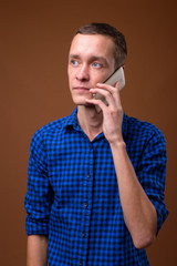 Studio shot of young man against brown background