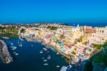Fototapeta na wymiar Perfect tiny seaside village with multi colored houses of Marina di Corricella, Procida Island, Naples Italy