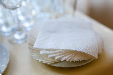 Paper napkins on white taralee in perspective isolated. Swipe close - up view from above. A stack of paper napkins with a shadow. Paper napkin on wooden table close - up view from above - obrazy, fototapety, plakaty