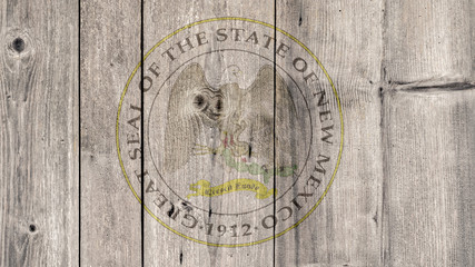 USA Politics News Concept: US State New Mexico Seal Wooden Fence Background
