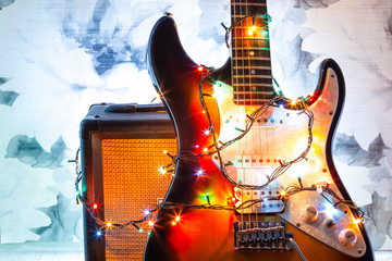 electric guitar and amplifier in bright colors of festive lights of the garland