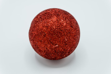 Red glittered christmas ball on white.