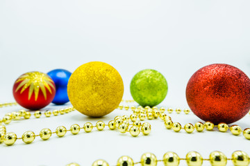 Red, green, gold, blue christmas balls and a golden chord.