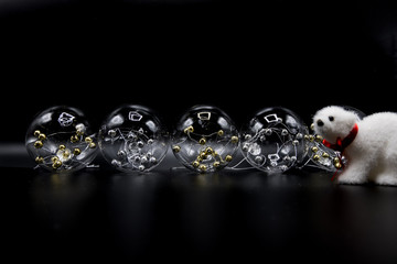 Transparent Christmas balls with golden spheres inside and polar bear toy.