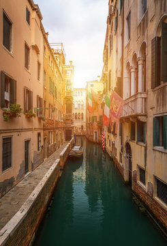 View of the street canal in Venice, Italy. Colorful facades of old Venice houses. Venice is a popular tourist destination of Europe. Venice, Italy.