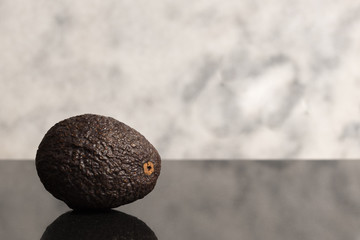 isolated avocado on dark granite with white granite background	